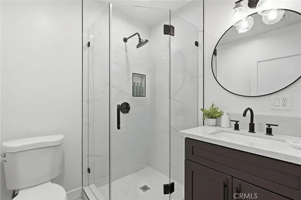 a living room with stainless steel appliances furniture and a wooden floor