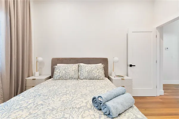 a large bed sitting in a bedroom next to a window with chair and couch