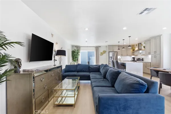 a living room with furniture and kitchen