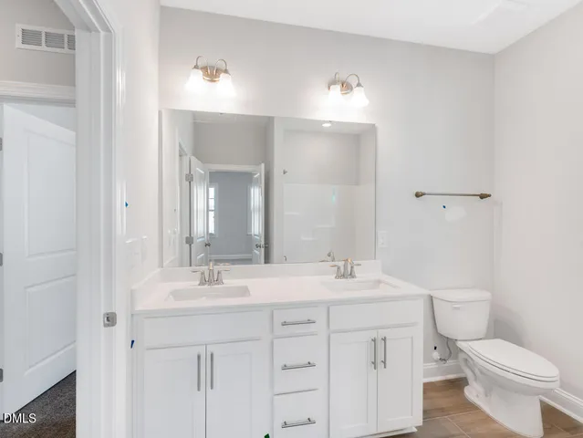 a bathroom with a double vanity sink a mirror and a bathtub