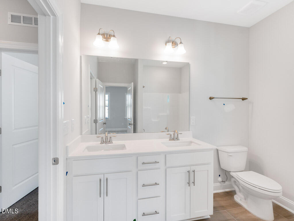 348 Canyon Gap Way Raleigh, NC 27610 - Photo 21 of 33 a bathroom with a sink a toilet a mirror and a vanity