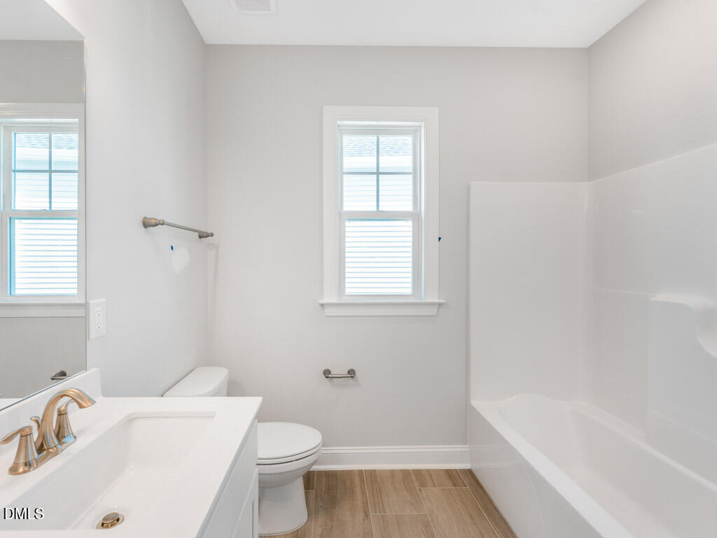 348 Canyon Gap Way Raleigh, NC 27610 - Photo 22 of 33 a white bath tub sitting next to a white toilet and sink