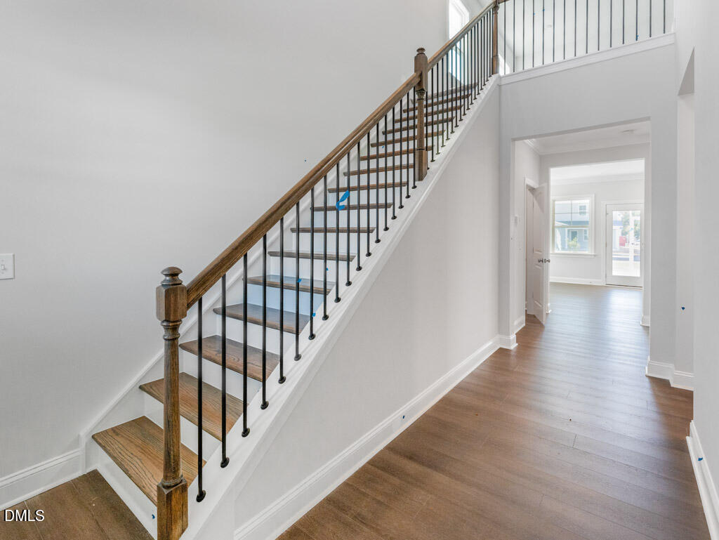348 Canyon Gap Way Raleigh, NC 27610 - Photo 4 of 33 a view of staircase with wooden floor and white walls