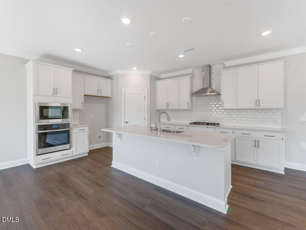 348 Canyon Gap Way Raleigh, NC 27610 - Photo 6 of 33 a kitchen with stainless steel appliances kitchen island granite countertop a stove a sink and white cabinets