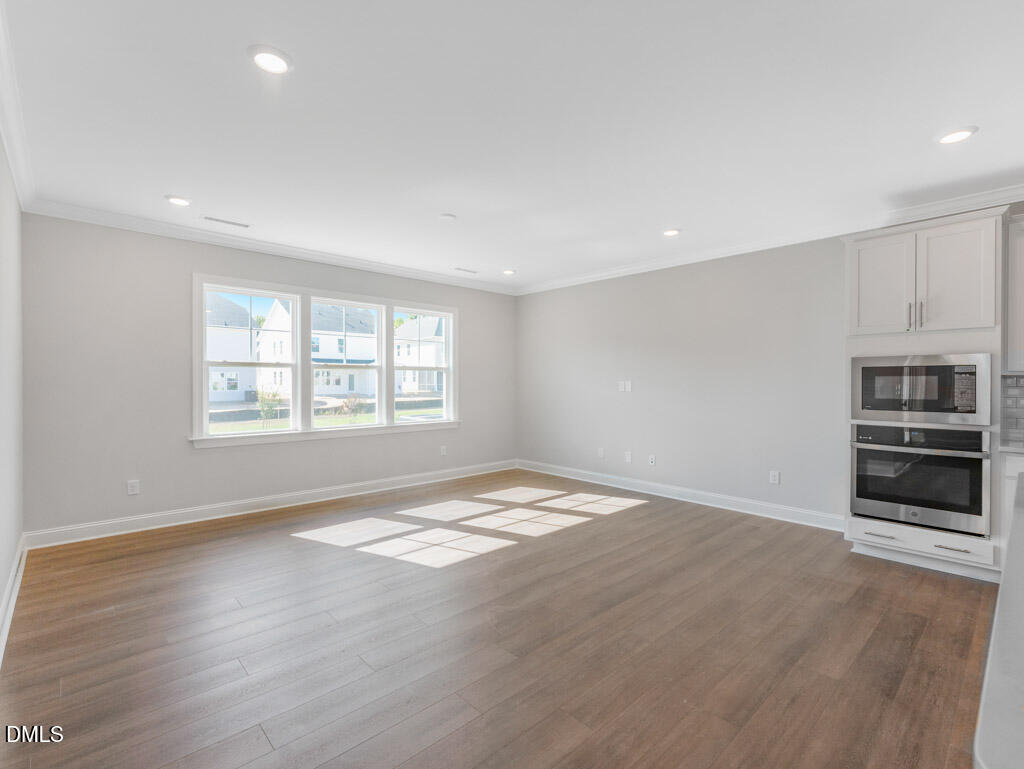 348 Canyon Gap Way Raleigh, NC 27610 - Photo 7 of 33 a view of an empty room with a window and a kitchen