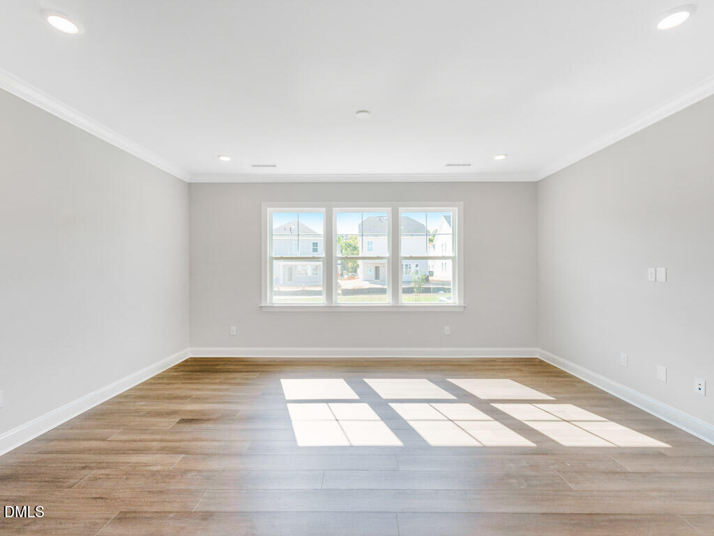 348 Canyon Gap Way Raleigh, NC 27610 - Photo 9 of 33 an empty room with wooden floor and windows