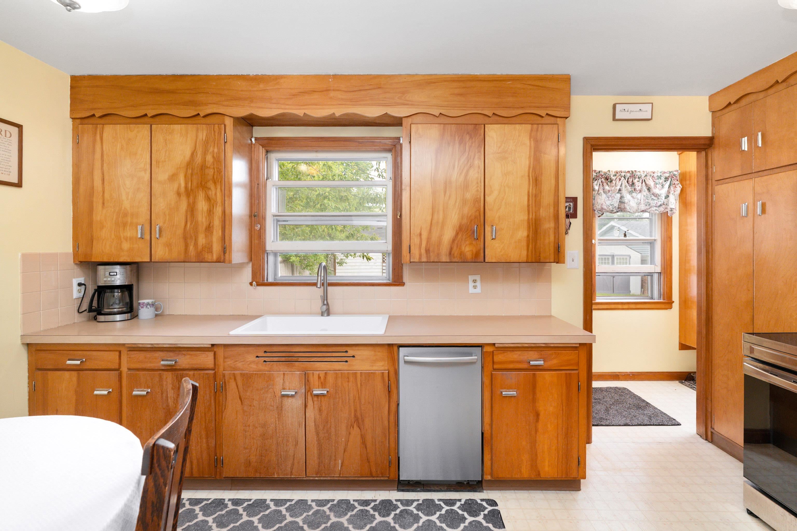 4621 Oneida Street Duluth, MN 55804 - Photo 17 of 47 Kitchen featuring decorative backsplash, light countertops, light flooring, stainless steel appliances, and brown cabinets