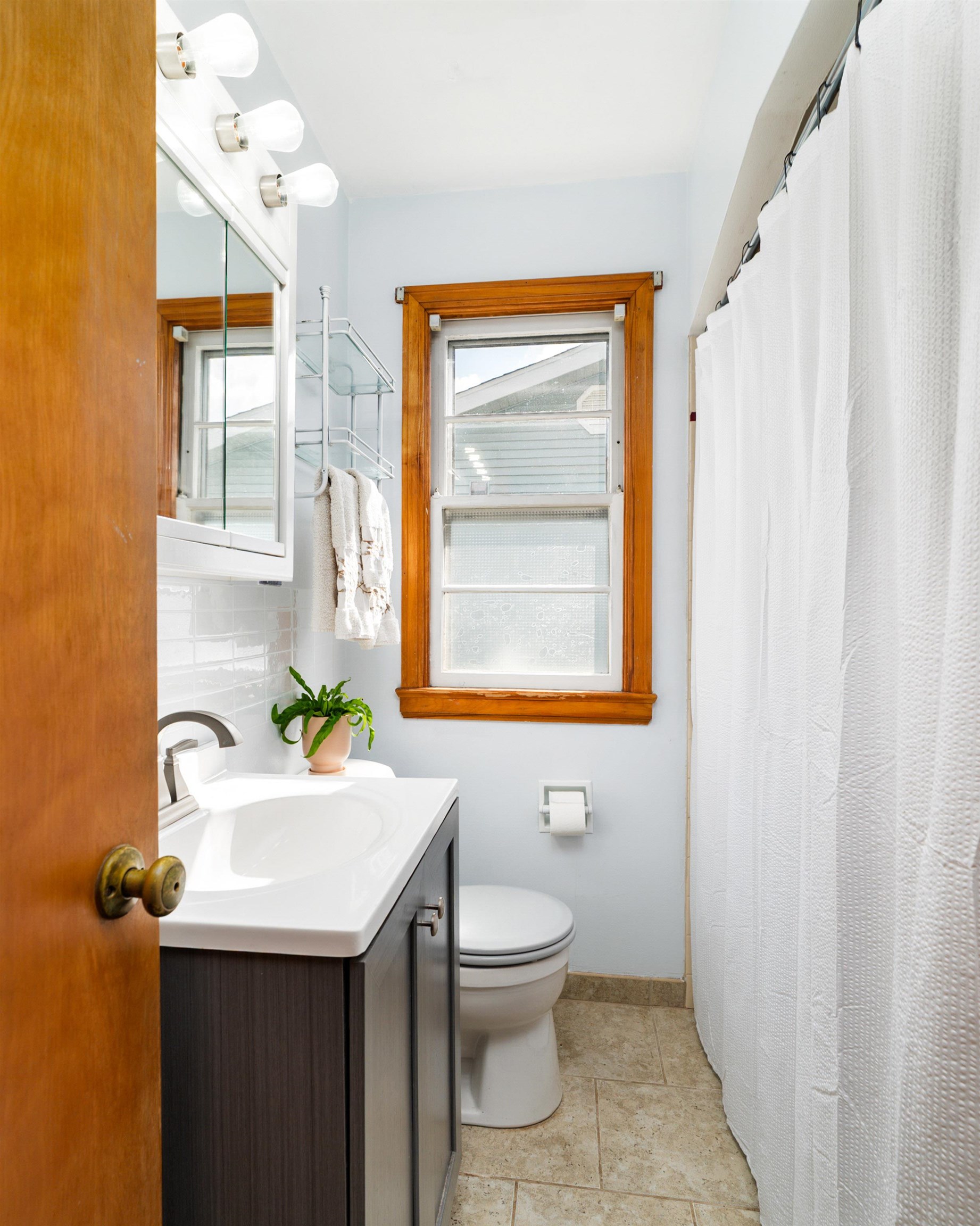 4621 Oneida Street Duluth, MN 55804 - Photo 21 of 47 Bathroom featuring vanity, decorative backsplash, a shower with curtain, and light tile patterned floors