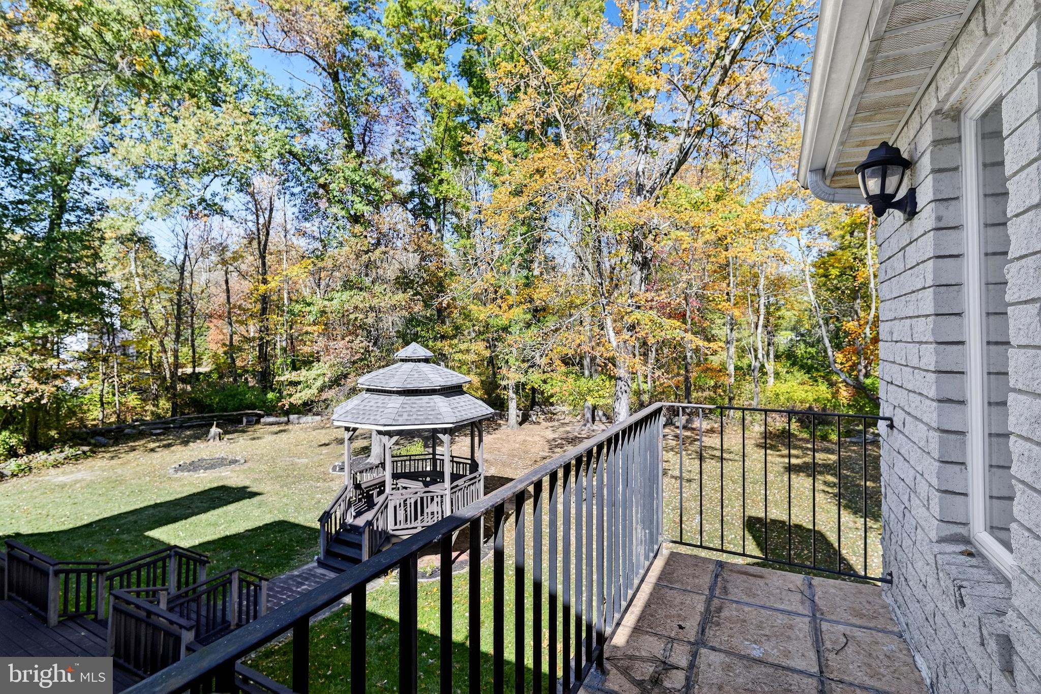 16 Benedek Road Princeton, NJ 08540 - Photo 37 of 60 a view of a balcony with a table and chairs under an umbrella with wooden fence