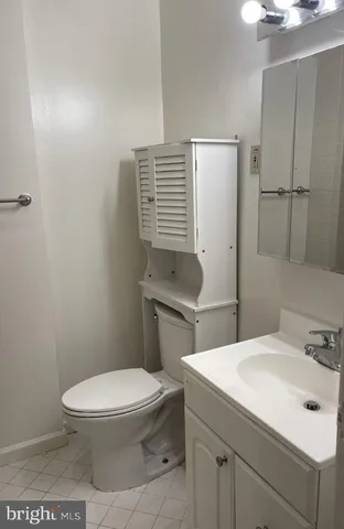 a bathroom with a toilet a sink and mirror