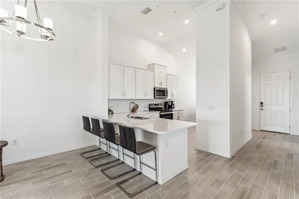 a kitchen with stainless steel appliances a sink a stove a refrigerator and cabinets
