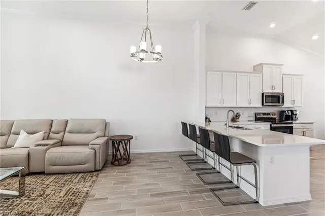 a living room with stainless steel appliances kitchen island granite countertop furniture and a view of kitchen