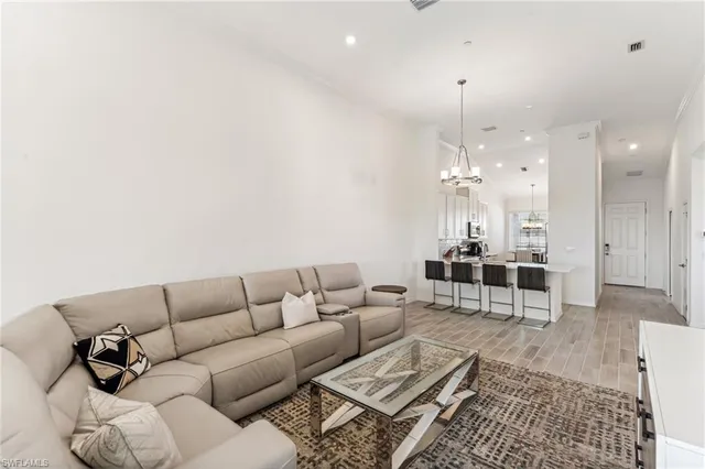 a living room with furniture a dining table and a chandelier