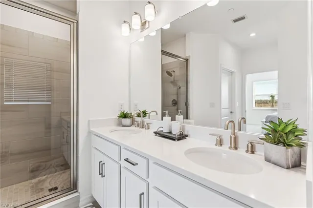 a bathroom with a double vanity sink a mirror and shower
