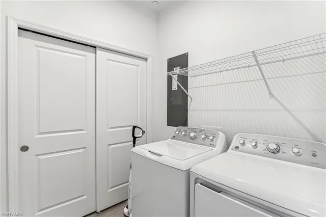 a view of washer and dryer with bathroom in the background