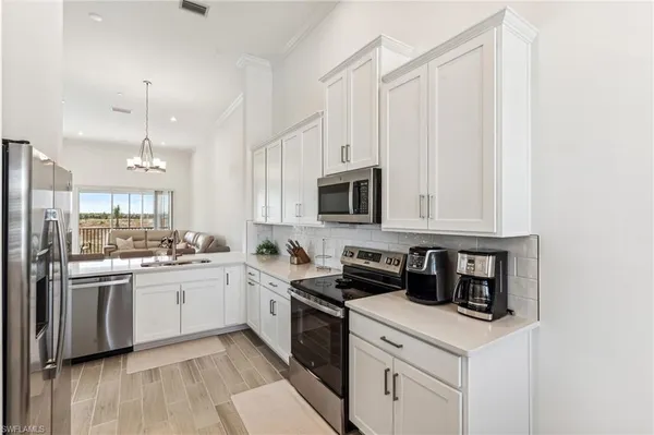 a kitchen with stainless steel appliances granite countertop a sink a stove a refrigerator and cabinets