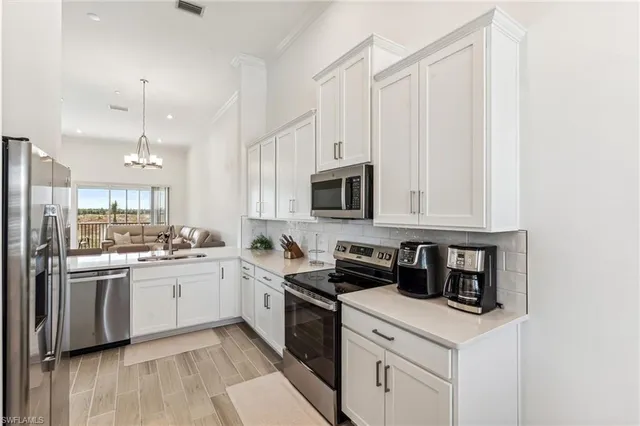 a kitchen with stainless steel appliances granite countertop a sink a stove a refrigerator and cabinets