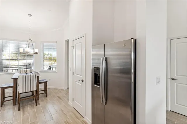 a kitchen with a refrigerator a dining table and chairs