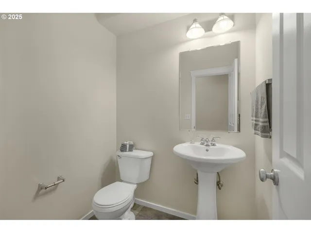 a bathroom with a sink mirror and toilet