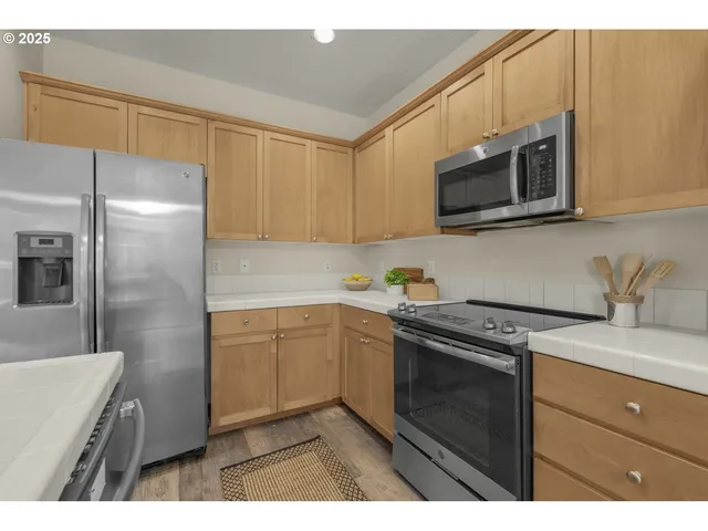 a kitchen with cabinets stainless steel appliances and a sink