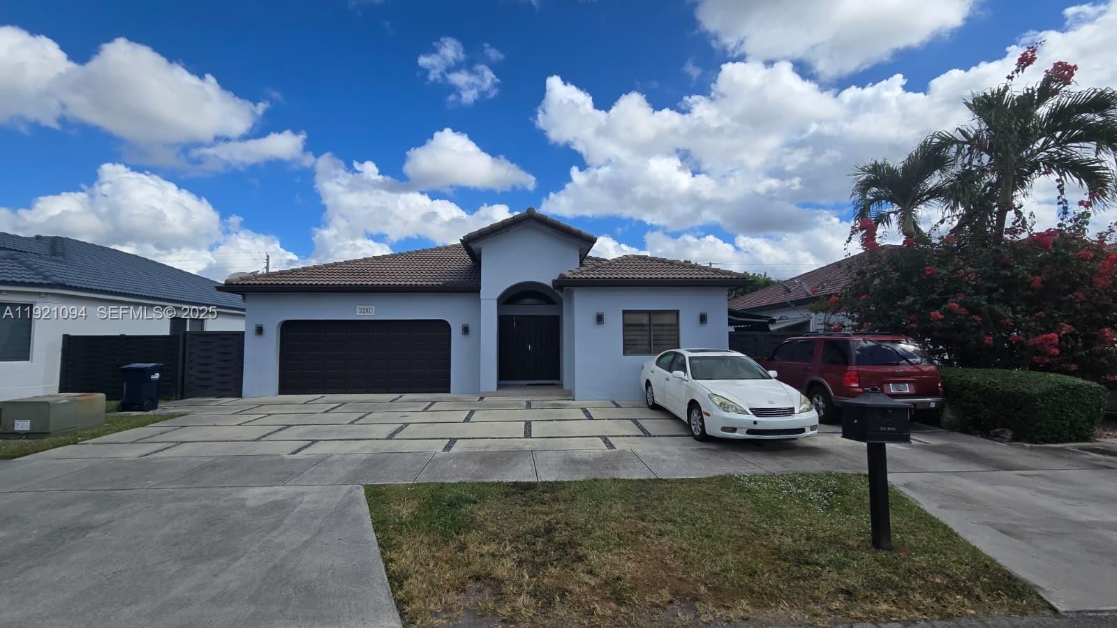 a front view of a house with cars parked