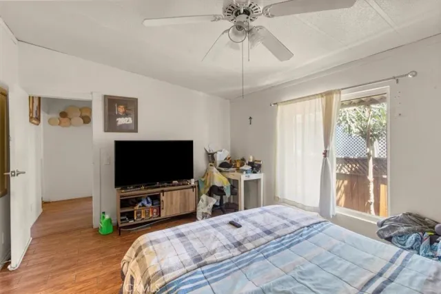 a bedroom with a bed and a flat tv screen on dresser