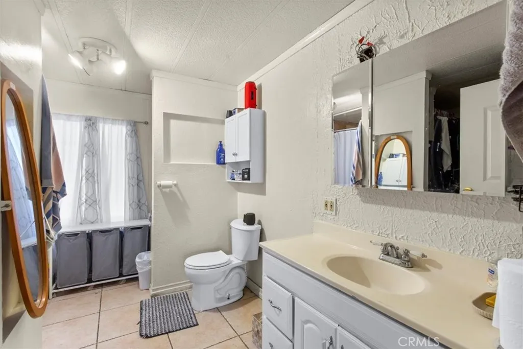 9080 Bloomfield Avenue, Unit 33 Cypress, CA 90630 - Photo 24 of 30 a bathroom with a toilet sink and mirror