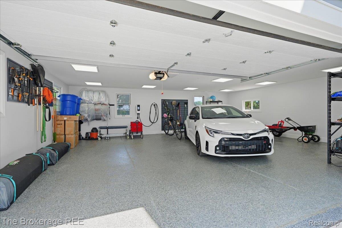261 Reymont Road Waterford, MI 48327 - Photo 30 of 49 Spacious garage featuring a durable epoxy floor, recessed lighting, multiple windows, and two electric vehicle charging stations
