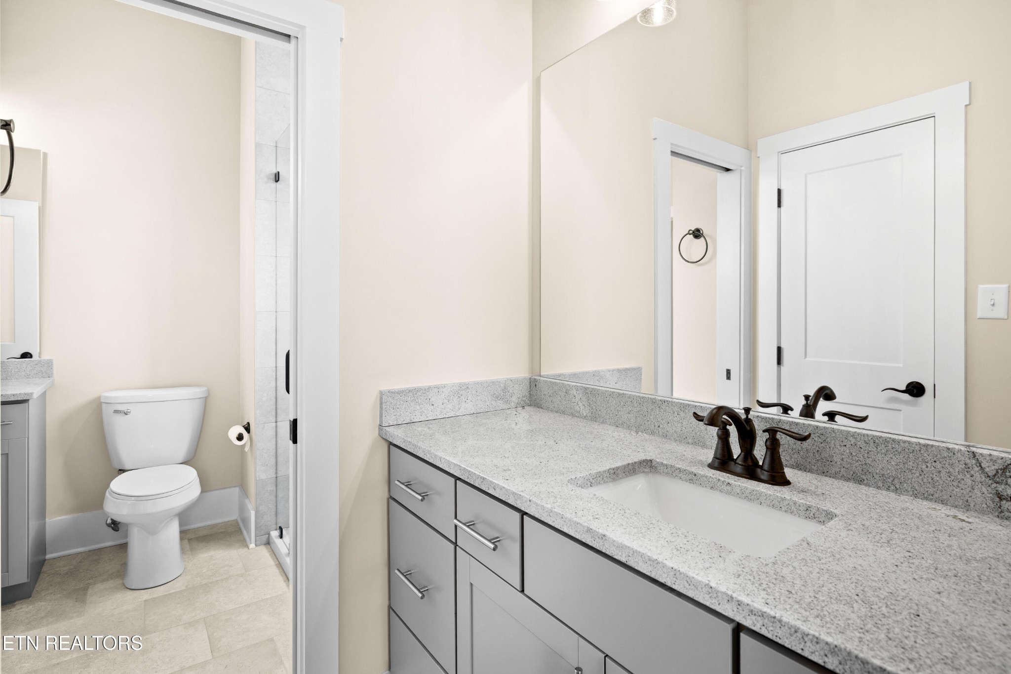 7791 Morganton Road Greenback, TN 37742 - Photo 39 of 53 a bathroom with a granite countertop sink a toilet and a mirror