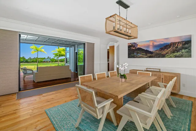 a view of a dining room with furniture a chandelier and wooden floor