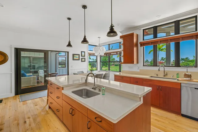 a kitchen with stainless steel appliances granite countertop a sink a stove and a wooden floors