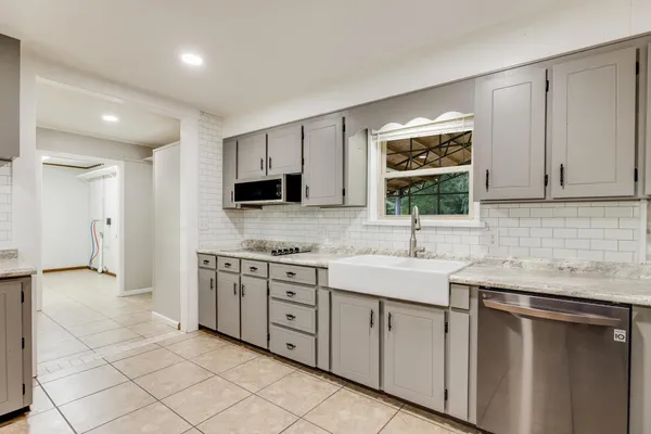 a kitchen with granite countertop stainless steel appliances and white cabinets