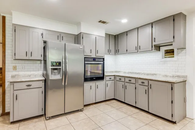 a kitchen with metallic refrigerator freezer and a dishwasher