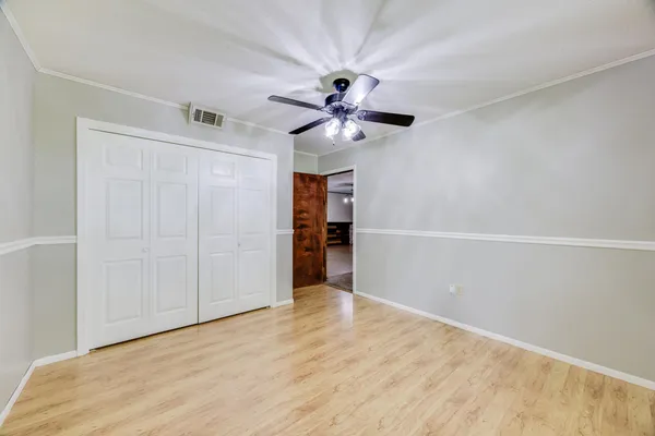 a view of an empty room with a window and a chandelier fan