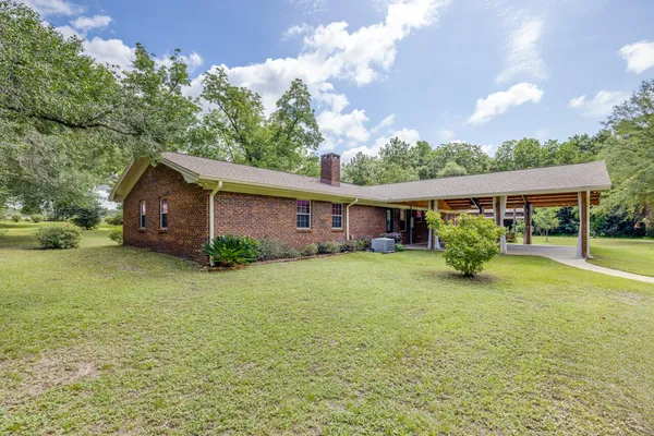 a view of a house with a yard and tree