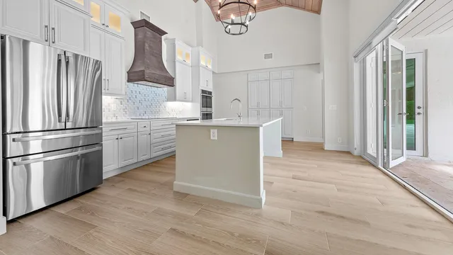 a kitchen with stainless steel appliances a refrigerator a sink a stove a microwave and island