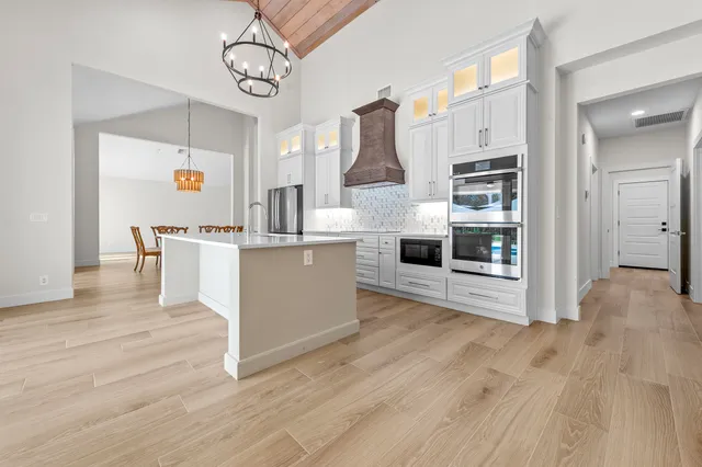 a view of kitchen with stainless steel appliances cabinets and wooden floor