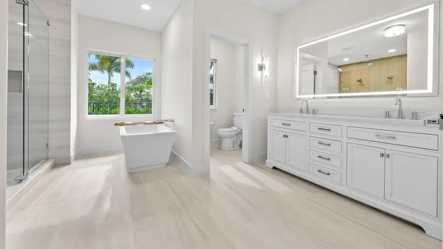 a spacious bathroom with a granite countertop sink mirror and bathtub