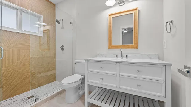 a bathroom with a sink a toilet and shower