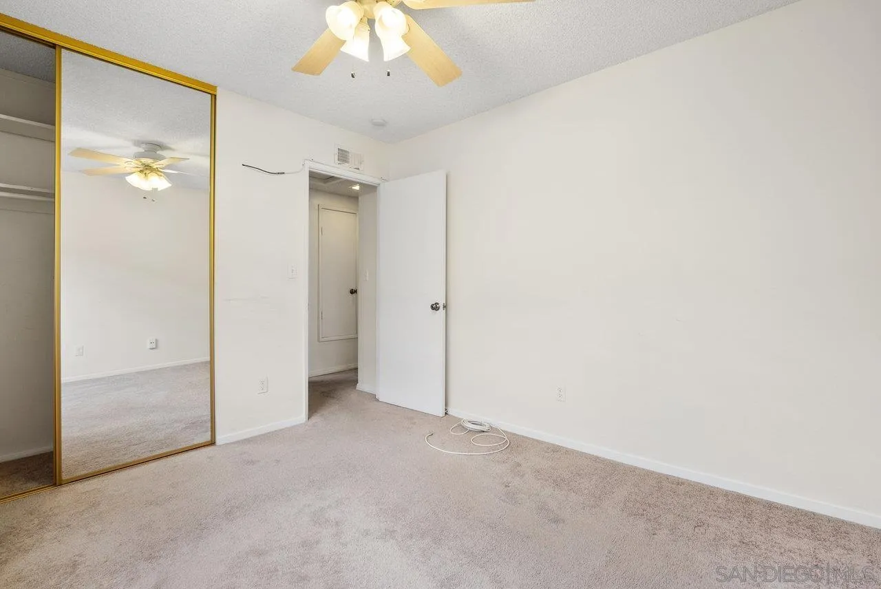 8715 Vista Del Verde El Cajon, CA 92021 - Photo 23 of 30 an empty room with a chandelier fan and a bathroom