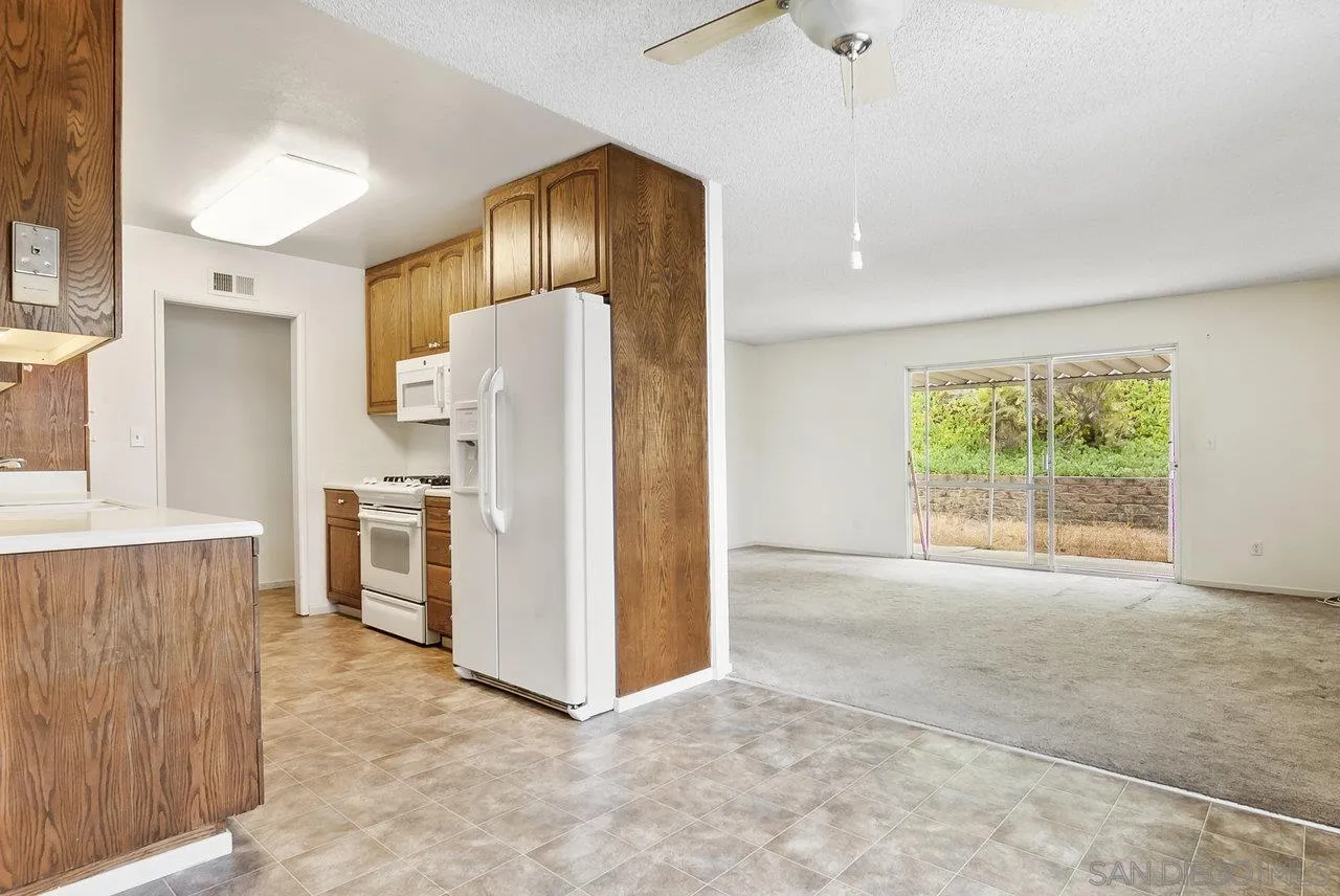 8715 Vista Del Verde El Cajon, CA 92021 - Photo 9 of 30 a view of a kitchen with a refrigerator wooden cabinets and a window