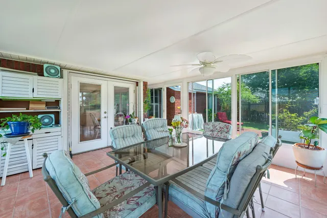 a living room with patio furniture and a large window