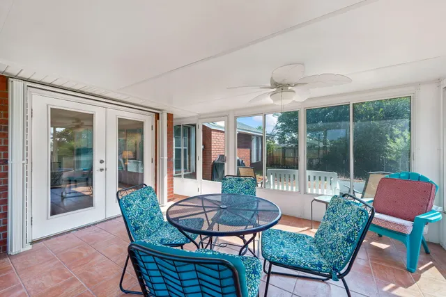 a dining room with furniture and large windows