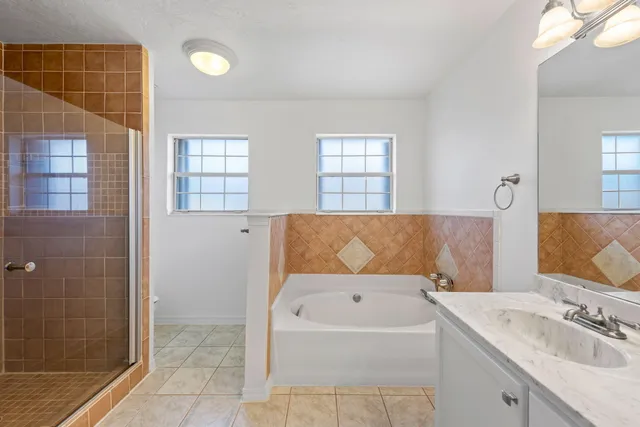 a bathroom with a tub a double vanity sink and a mirror