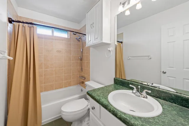 a view of a house next to a big yard and large trees