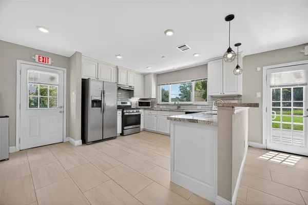 a kitchen with stainless steel appliances a refrigerator sink and cabinets