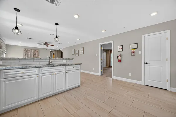 a large kitchen with stainless steel appliances granite countertop a sink and cabinets