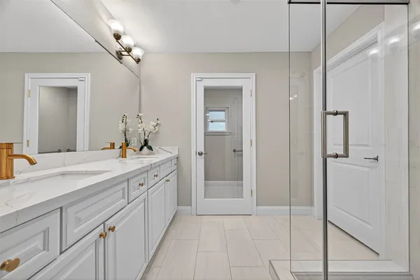 a spacious bathroom with a granite countertop sink a mirror and shower