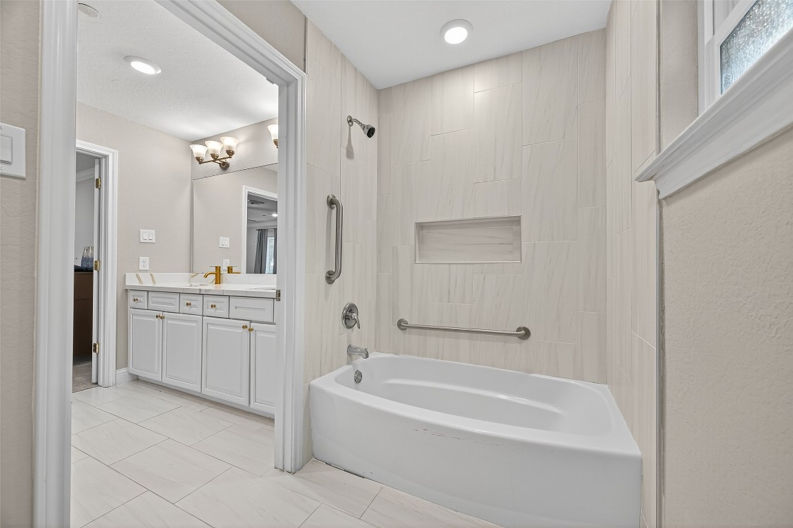 29902 East Hawthorne Drive Spring, TX 77386 - Photo 23 of 43 a bathroom with a granite countertop sink a mirror a bathtub and shower