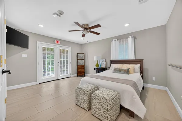 a spacious bedroom with a large bed and a chandelier